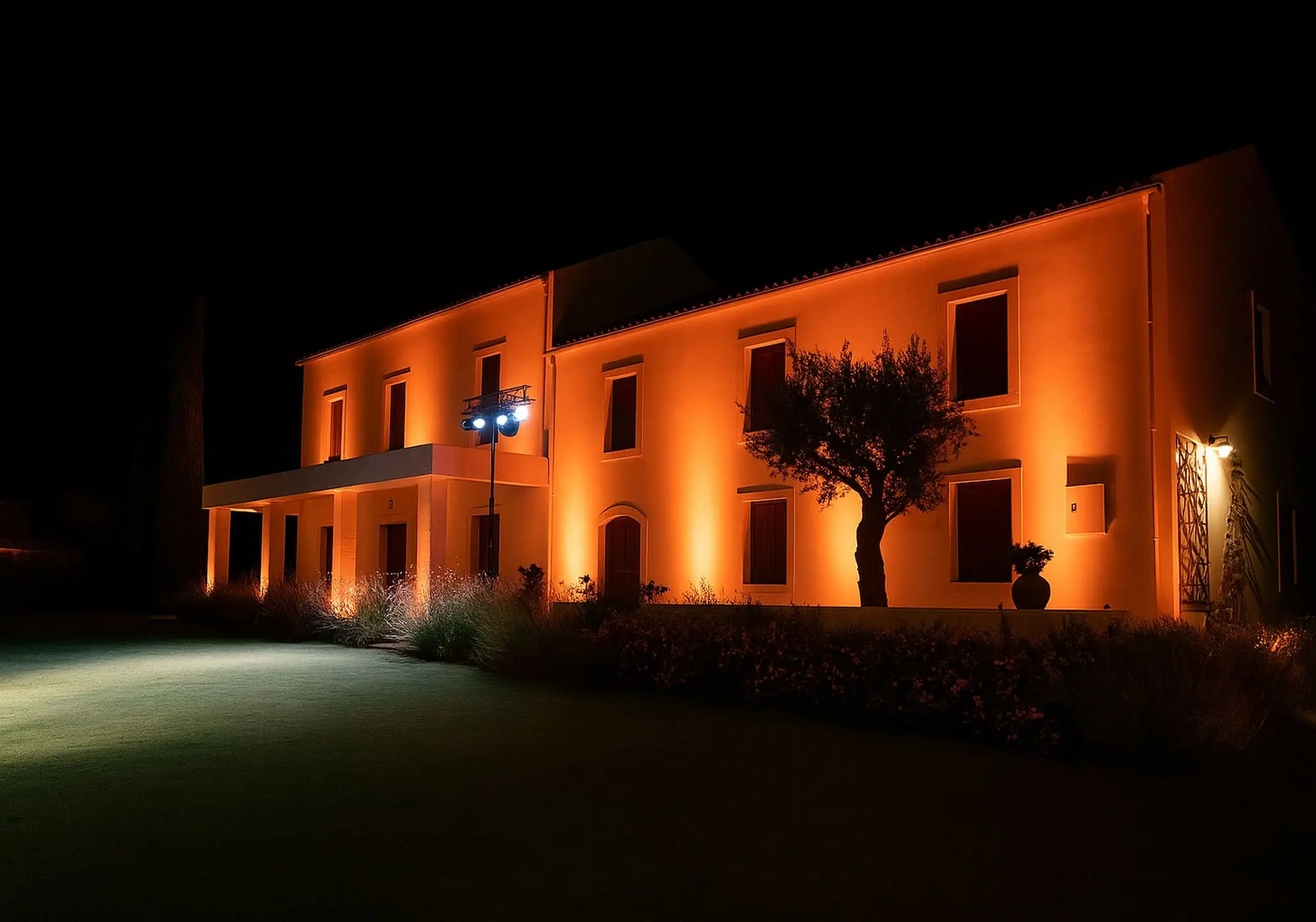 Μια χαμογελαστή νύφη και γαμπρός κρατούν μαζί ένα μαχαίρι για να κόψουν την πολυώροφη γαμήλια τούρτα τους κατά τη διάρκεια της δεξίωσης στο Κτήμα Ρωξάνη.